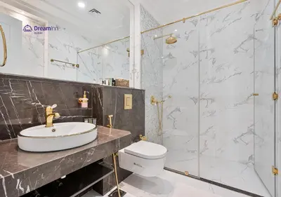 a bathroom with a toilet and a sink and a shower at Dream Inn - Modern 1BR in Arjan in Dubai