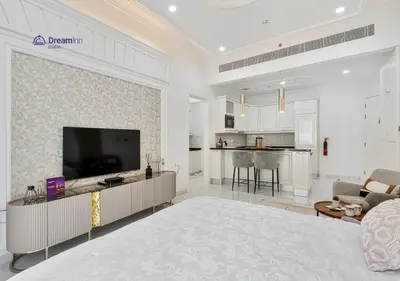 a white living room with a television and a living room at Dream Inn - Modern 1BR in Arjan in Dubai