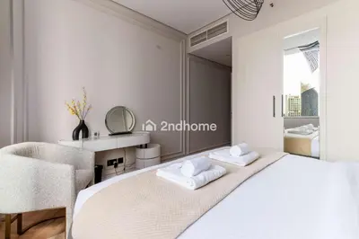 a bedroom with a bed and a chair and a mirror at Stylish 2Bedroom in DIFC Dubai Newly Furnished in Dubai