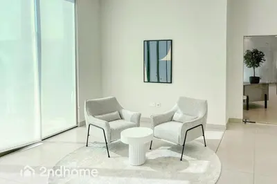 two chairs and a table in a white room at Downtown Views 1 - Direct Access to Dubai Mall in Dubai