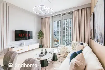 a living room with a white couch and a tv at Downtown Views 1 - Direct Access to Dubai Mall in Dubai