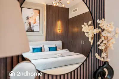 a bedroom with a bed with blue pillows and a mirror at Downtown Views 1 - Direct Access to Dubai Mall in Dubai