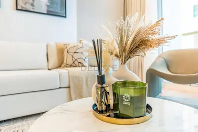 a living room with a coffee table with a vase at Renovated 1BR with Partial Sea and City Views Near Beach, Elite Residence, Dubai Marina by Deluxe Holiday Homes in Dubai