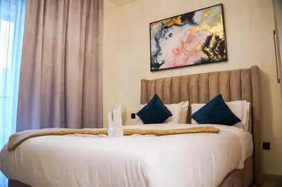 a bedroom with a large white bed with blue pillows at Vserve 2BR Perfect Blend of Luxury Comfort & Convenience in Dubai