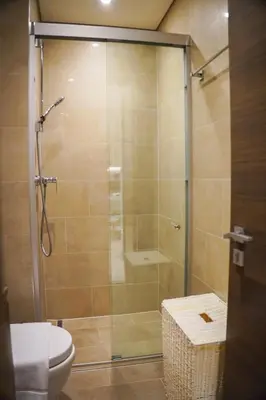 a shower stall in a bathroom with a toilet at Vserve 2BR Perfect Blend of Luxury Comfort & Convenience in Dubai