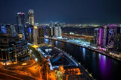a city at night with a river and buildings at Luxury & Modern studio near Burj Khalifa in Dubai