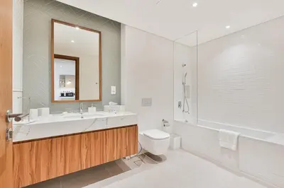 a bathroom with a sink and a toilet and a tub at Chic 1BR APT with Pool, Gym & Kid's Playground in Dubai