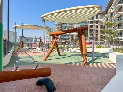 a playground with a bench and a swing at Chic 1BR APT with Pool, Gym & Kid's Playground in Dubai