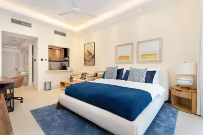 a bedroom with a large bed and a desk at Renovated Studios in Nature at Discovery Gardens in Dubai