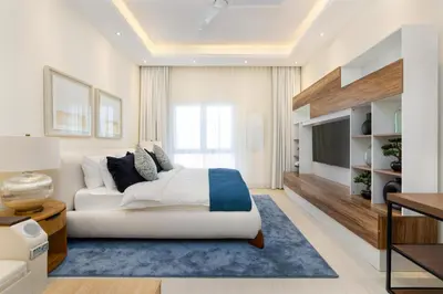 a bedroom with a large bed and a tv at Renovated Studios in Nature at Discovery Gardens in Dubai