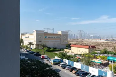 a parking lot with cars parked in front of a building at Renovated Studios in Nature at Discovery Gardens in Dubai