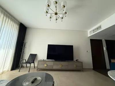 a living room with a television and a chandelier at Sparkle Towers by Swarovski - Dubai Marina - High Floor - Beach Resort Sunset view in Dubai