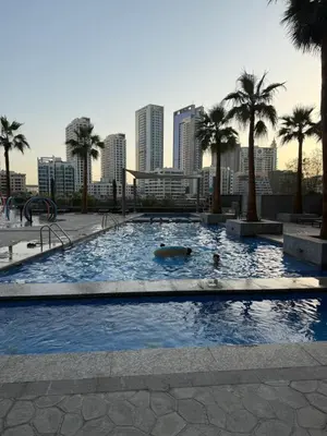a large swimming pool with palm trees and a city at Sparkle Towers by Swarovski - Dubai Marina - High Floor - Beach Resort Sunset view in Dubai
