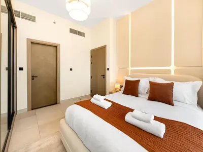 a bedroom with a large bed with towels on it at Casa Tranquila Luxury Suites with Burj Khalifa & Canal Views in Dubai