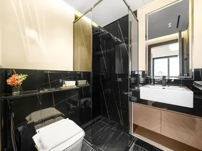 a bathroom with a toilet and a sink and a mirror at Casa Tranquila Luxury Suites with Burj Khalifa & Canal Views in Dubai