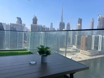 a balcony with a table and a view of the city at Casa Tranquila Luxury Suites with Burj Khalifa & Canal Views in Dubai