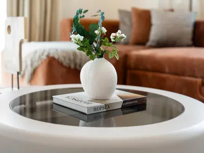 a table with a vase on top of three books at Casa Tranquila Luxury Suites with Burj Khalifa & Canal Views in Dubai