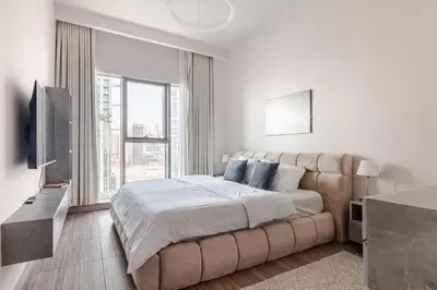 a white bedroom with a large bed and a large window at ZenStay - Haven of tranquility and luxury in Dubai