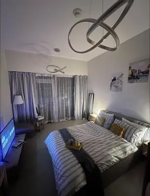 a bedroom with a bed and a chandelier at Vibrant studio - 15m to marina in Dubai