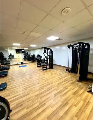 a gym with tread machines and a wooden floor at Vibrant studio - 15m to marina in Dubai