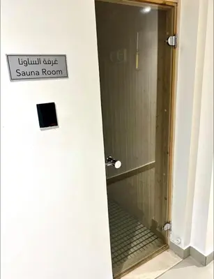 a bathroom with a shower with a sign on the door at Vibrant studio - 15m to marina in Dubai