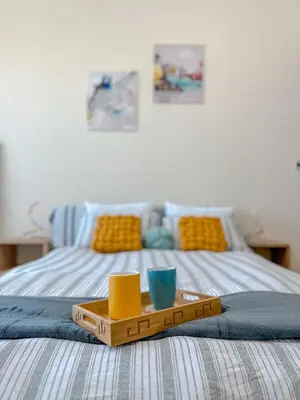 a tray on a bed with a meal on it at Vibrant studio - 15m to marina in Dubai