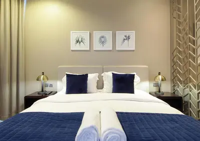 a bedroom with a large bed with blue pillows at Stylish Studio in Damac Prive Canal-View Studio in Dubai