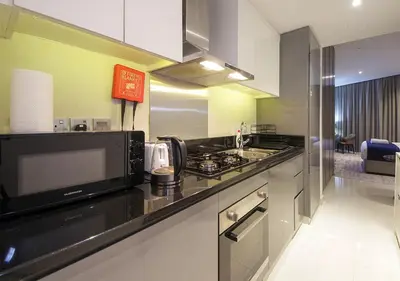 a kitchen with a black counter top and a microwave at Stylish Studio in Damac Prive Canal-View Studio in Dubai