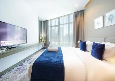 a hotel room with a large bed and a flat screen tv at Stylish Studio in Damac Prive Canal-View Studio in Dubai
