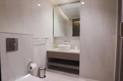 a white bathroom with a sink and a mirror at Stunning Studio in Peninsula Five in Dubai