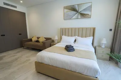 a hotel room with a bed and a chair at Stunning Studio in Peninsula Five in Dubai
