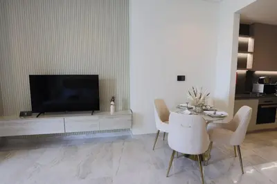 a living room with a tv and a table and chairs at Stunning Studio in Peninsula Five in Dubai