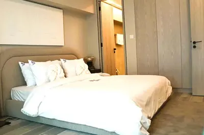 a hotel room with a bed with white sheets at Casa Royale Vacation Home - JVC in Dubai