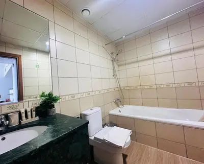 a bathroom with a tub and a toilet and a sink at Airvistas Elevate Living 1BHK in Dubai