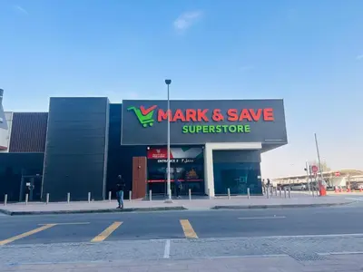 a man standing in front of a markup and save supermarket at Airvistas Elevate Living 1BHK in Dubai