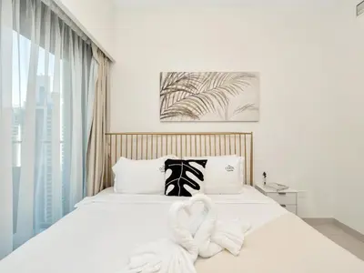 a bedroom with a white bed with a large window at Stylish 3BR in BurjCrown Balcony & HighEnd Comfort in Dubai