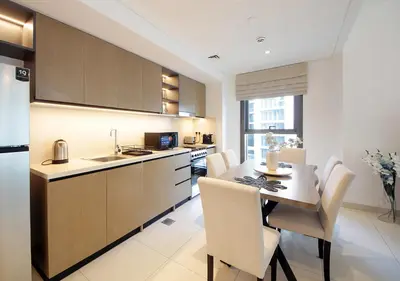 a kitchen with a table and chairs and a kitchen with a sink at Upscale2BR in Burj Crown Pool,Gym & Stunning Views in Dubai