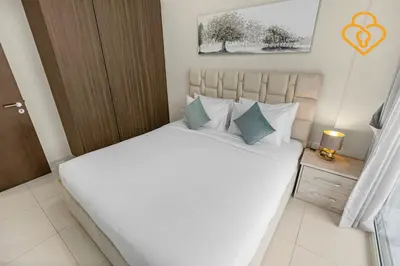 a bedroom with a large white bed with blue pillows at Keysplease 1 BR Apt, Vera Residence Business Bay in Dubai