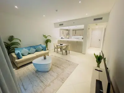 a living room with a couch and a table at Vserve Comfy & Relaxing 1 BDR Retreat At the Palm in Dubai