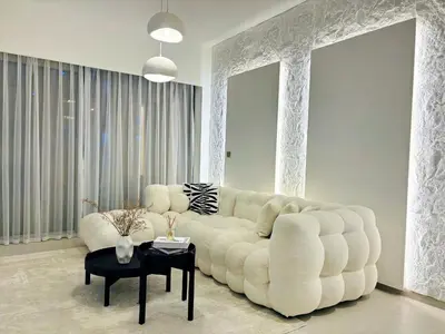 a living room with a large white couch and a table at Luxury 1BR Apt Best view Infinity Pool Burj Khalifa with Balcony in Dubai