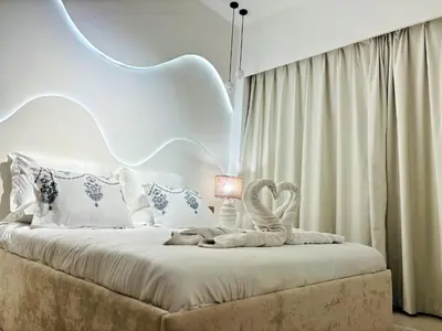a bedroom with a white bed with a swan on it at Luxury 1BR Apt Best view Infinity Pool Burj Khalifa with Balcony in Dubai