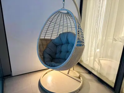 a swing chair sitting in a room next to a window at Luxury 1BR Apt Best view Infinity Pool Burj Khalifa with Balcony in Dubai