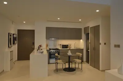 a kitchen and living room with a table and chairs at Luxury 1BR Apt Best view Infinity Pool Burj Khalifa with Balcony in Dubai
