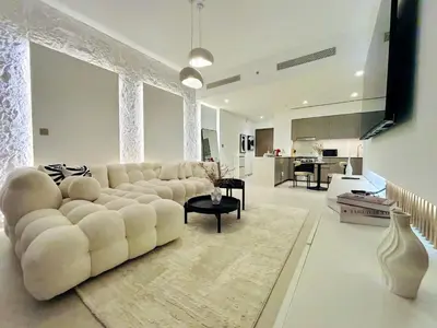 a living room with a white couch and a kitchen at Luxury 1BR Apt Best view Infinity Pool Burj Khalifa with Balcony in Dubai