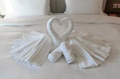 two towel swans making a heart on a bed at Damac Paramount Tower Burj Views in Dubai