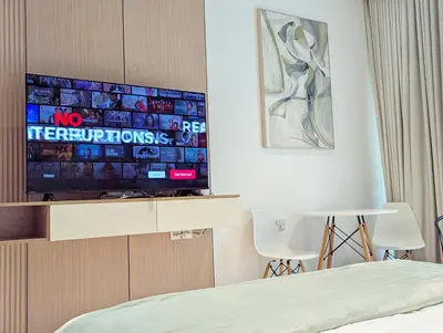 a hotel room with a tv and a bed at Waterfront Studio with Burj Khalifa & Dubai Mall Access, Walk to Dubai Water Canal & Business Bay Metro in Dubai