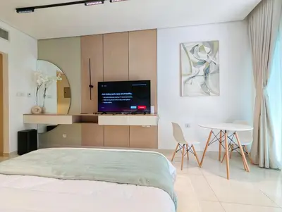 a bedroom with a bed and a tv and a table at Waterfront Studio with Burj Khalifa & Dubai Mall Access, Walk to Dubai Water Canal & Business Bay Metro in Dubai