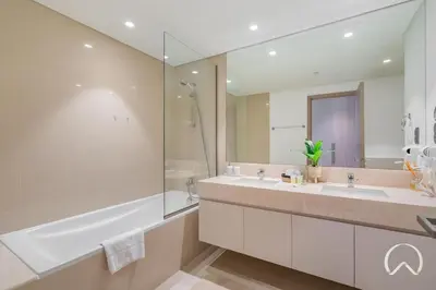 a bathroom with two sinks and a large mirror at Luxurious 4BR In Act 1 Act 2 With Burj Khalifa View in Dubai