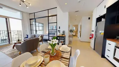 a kitchen and living room with a table and chairs at Tranquil Oasis 2BR at Collective Dubai Hills in Dubai