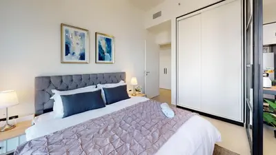 a bedroom with a large bed with blue pillows at Tranquil Oasis 2BR at Collective Dubai Hills in Dubai